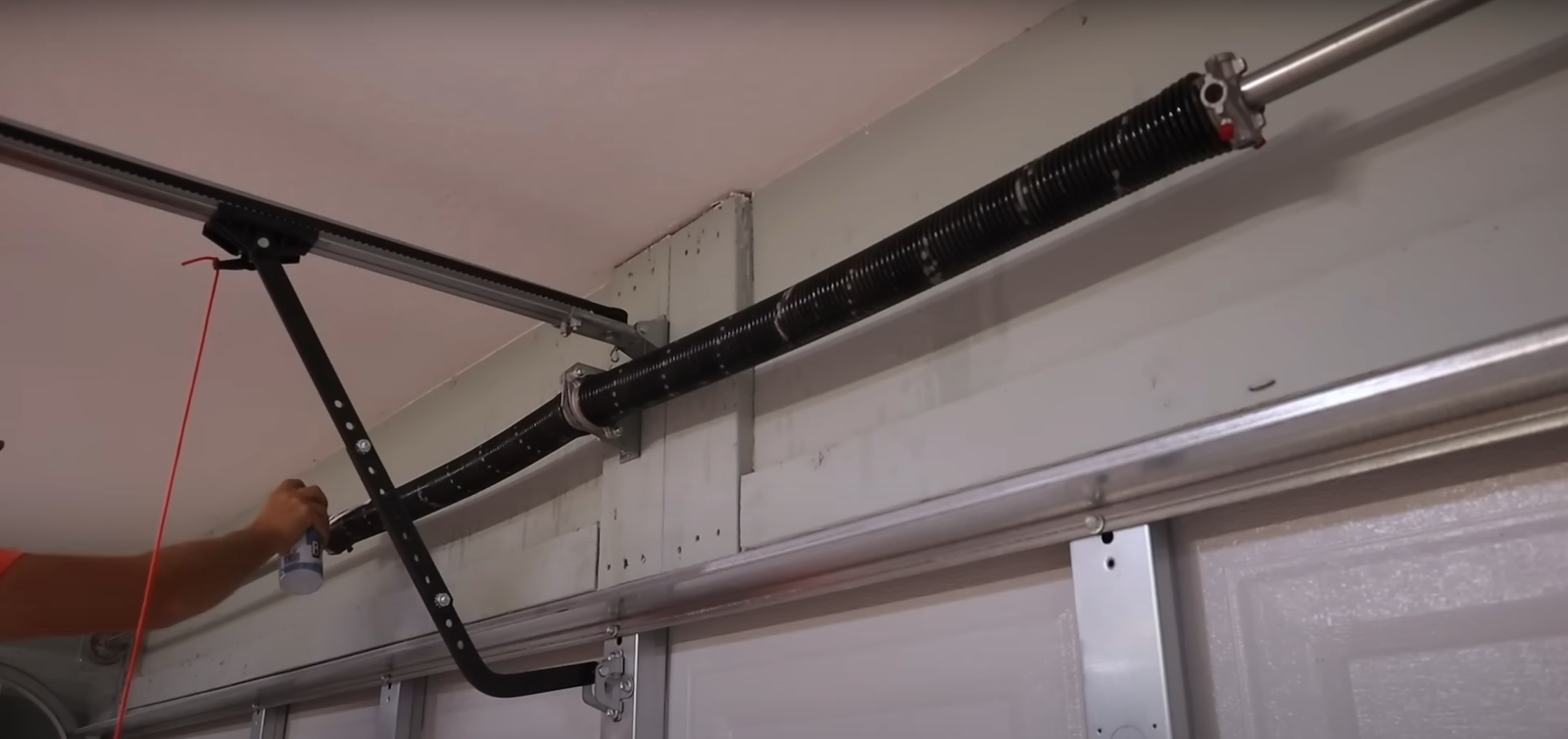 Garage door technician inspecting springs for potential issues - Boca Raton Garage Door Repair